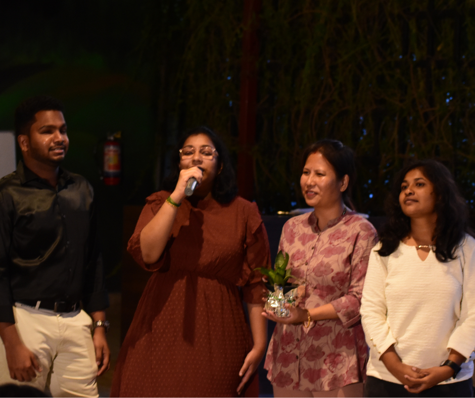 Participant speaking on microphone while others stand beside her at the Ability Awareness event.