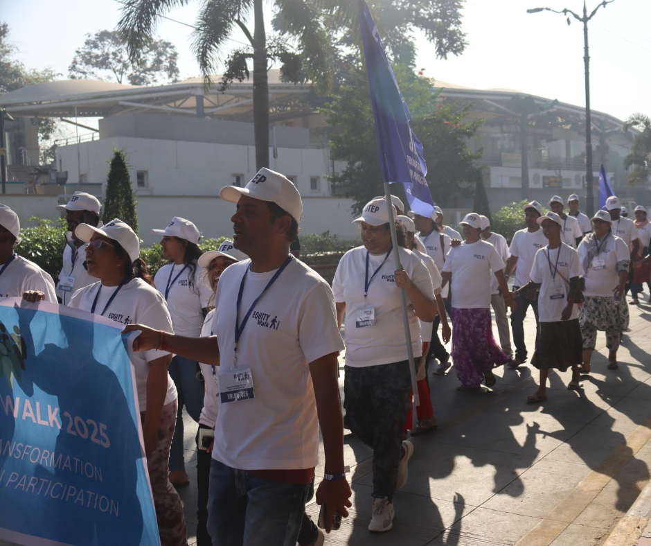 Group of volunteers participating in an outdoor awareness walk, wearing event t-shirts and caps.