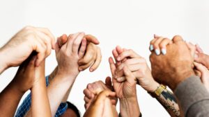 Group of diverse hands raised together in unity, symbolizing collective strength and diversity